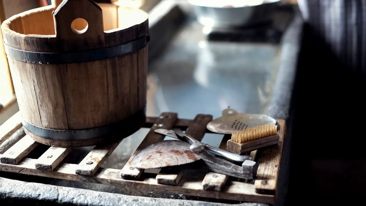 A wooden bucket, brush and other basic cleaning tools laid out together